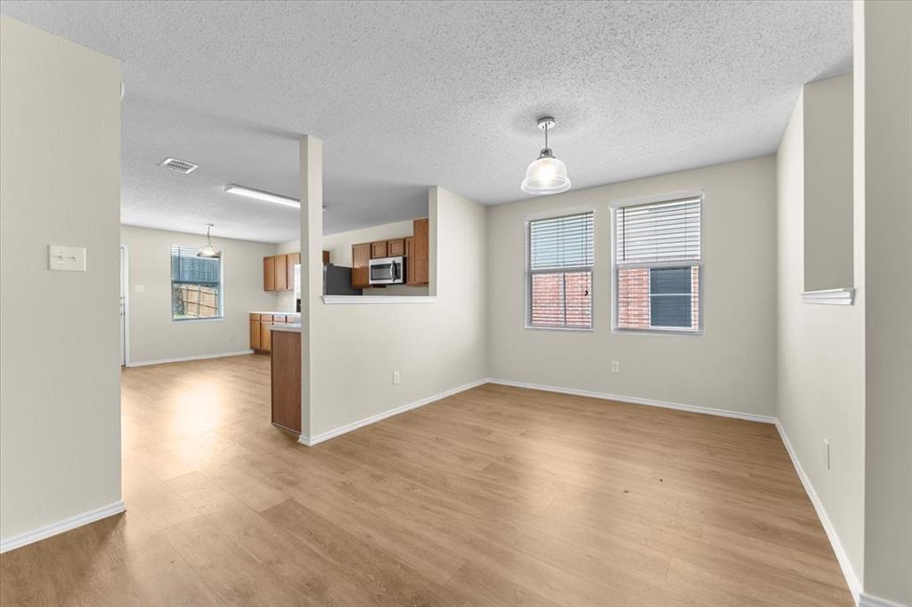 2633 Salt Maker Way Little Elm, TX 75068 - Photo 5 of 40 an empty room with wooden floor and windows