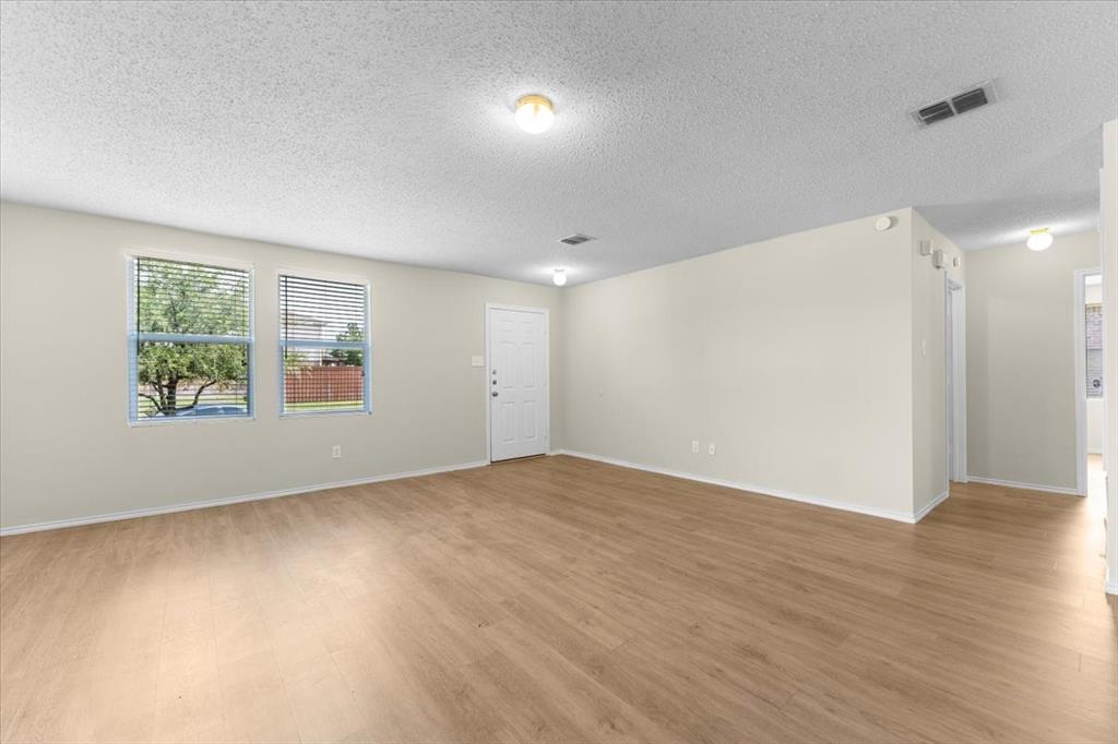 2633 Salt Maker Way Little Elm, TX 75068 - Photo 7 of 40 an empty room with wooden floor and windows