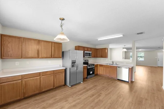 a kitchen with granite countertop wooden floors and stainless steel appliances