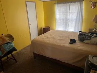 a bedroom with a bed and teddy bear on bed