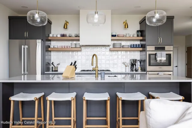 a kitchen with sink a counter and chairs