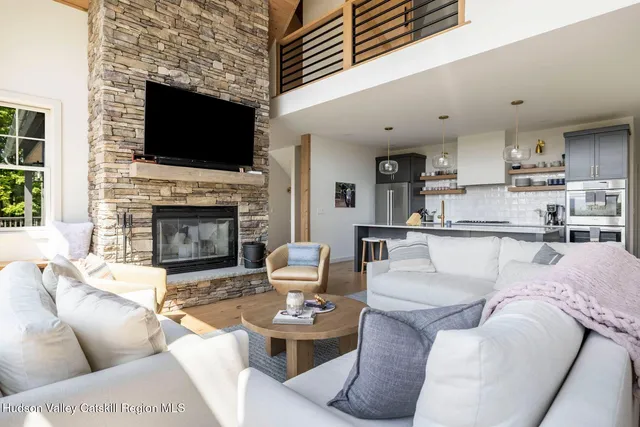 a living room with fireplace furniture and a large window
