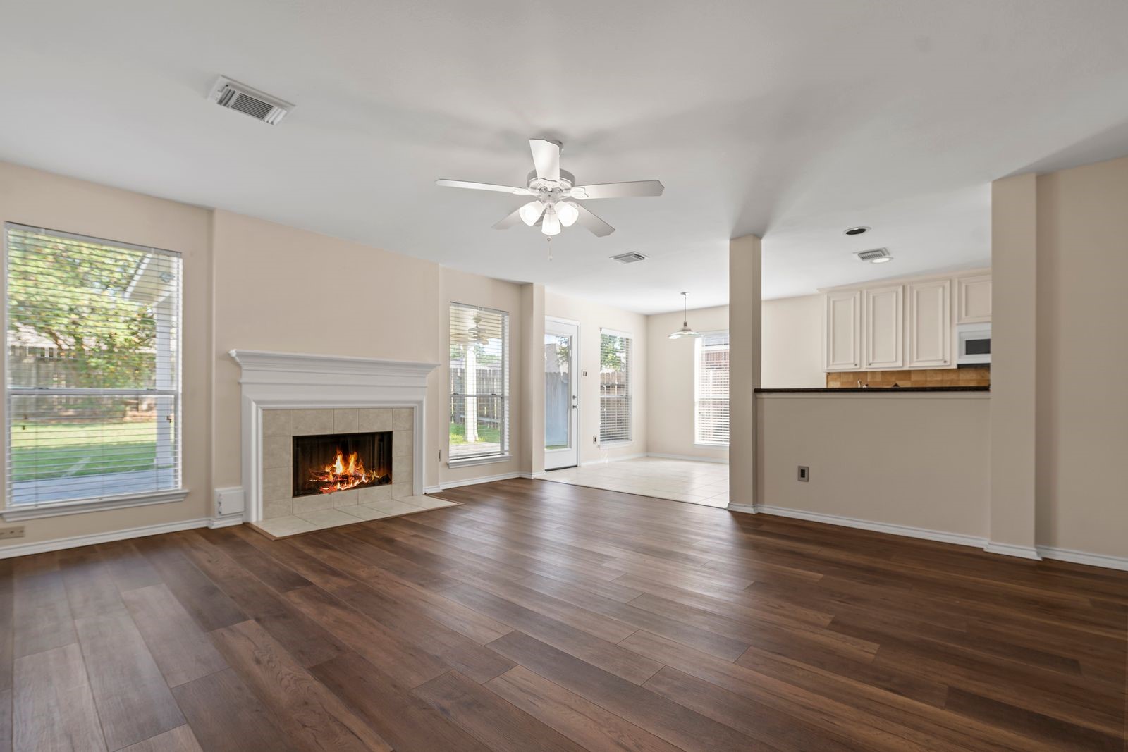 15311 Redbud Berry Way Cypress, TX 77433 - Photo 6 of 30 a view of an empty room with wooden floor a fireplace and a window