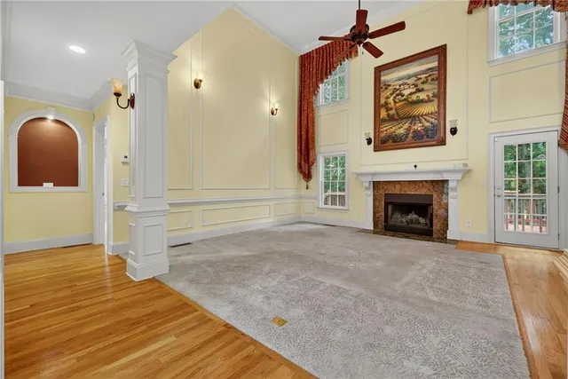 a view of an empty room with wooden floor and a fireplace