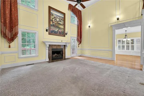 a view of an empty room with a fireplace and a window