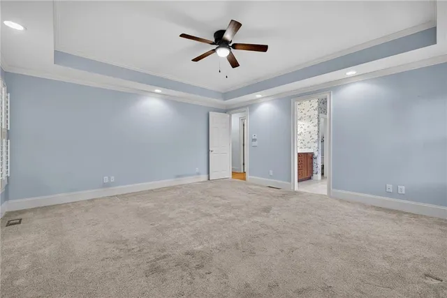 an empty room with ceiling fan and window