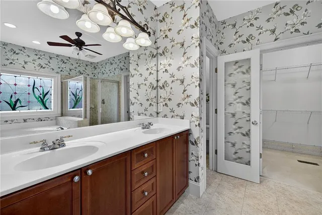 a bathroom with a double vanity sink mirror and shower