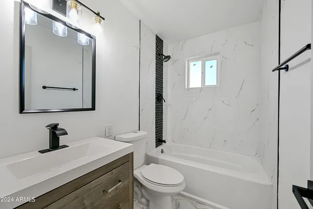 a bathroom with a sink a toilet a mirror and shower