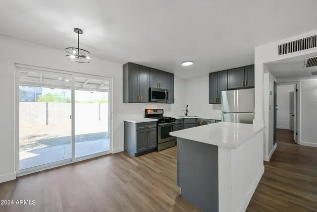 a kitchen with refrigerator cabinets and wooden floor