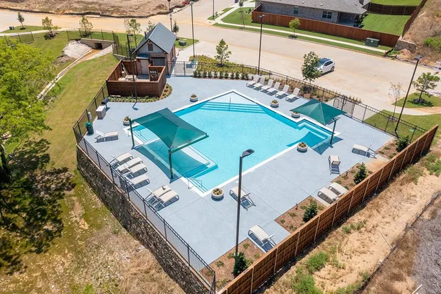 a view of a brick house with a big yard and large trees