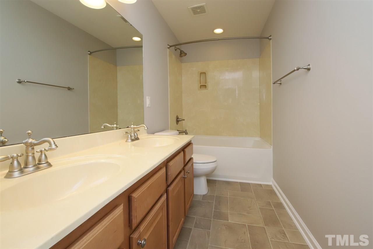 175 Solheim Lane Raleigh, NC 27603 - Photo 16 of 26 a bathroom with a granite countertop sink a toilet and shower