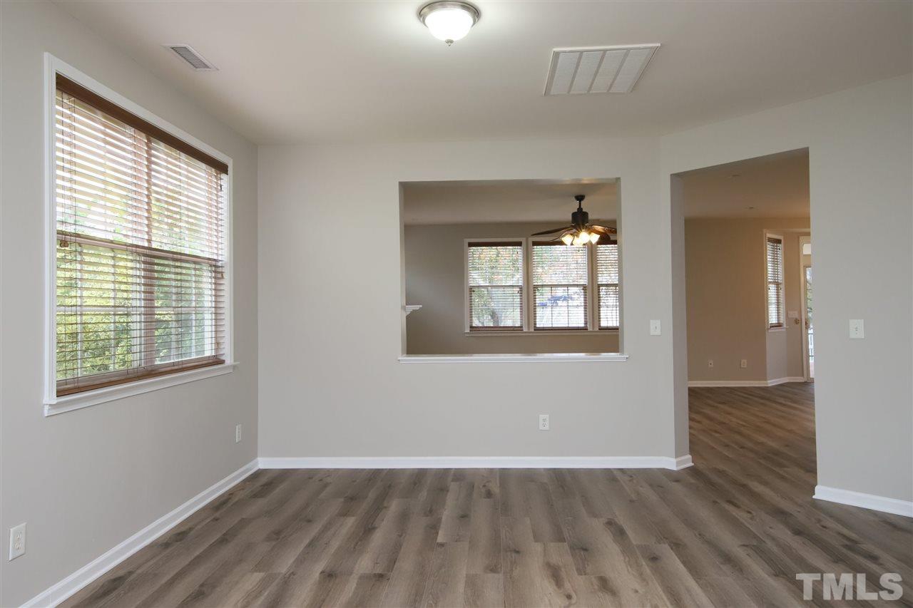 175 Solheim Lane Raleigh, NC 27603 - Photo 4 of 26 an empty room with wooden floor and windows