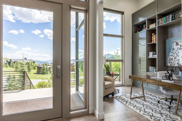 140 West Vista Road Kamas, UT 84036 - Photo 18 of 101 Wood-finish flooring, full-light entry door, tall fixed-pane window, built-in shelving, and a built-in desk