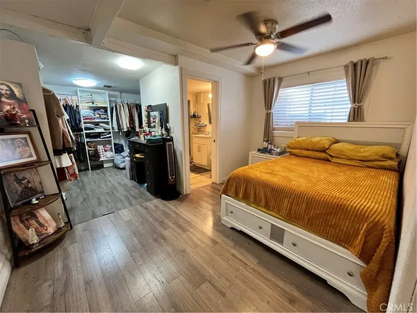 a bedroom with a bed and a flat tv screen on the dresser