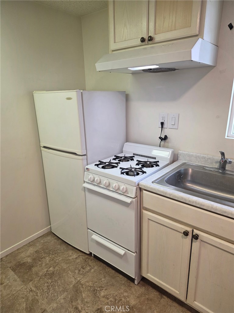 12188 Oracle Street Norwalk, CA 90650 - Photo 27 of 29 a white refrigerator freezer sitting inside of a kitchen