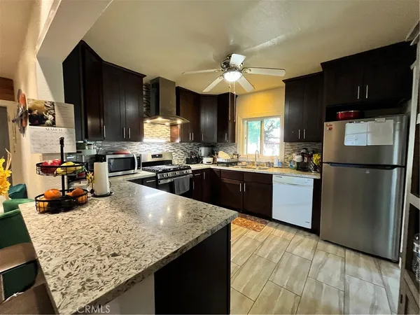 a kitchen with granite countertop stainless steel appliances and wooden cabinets