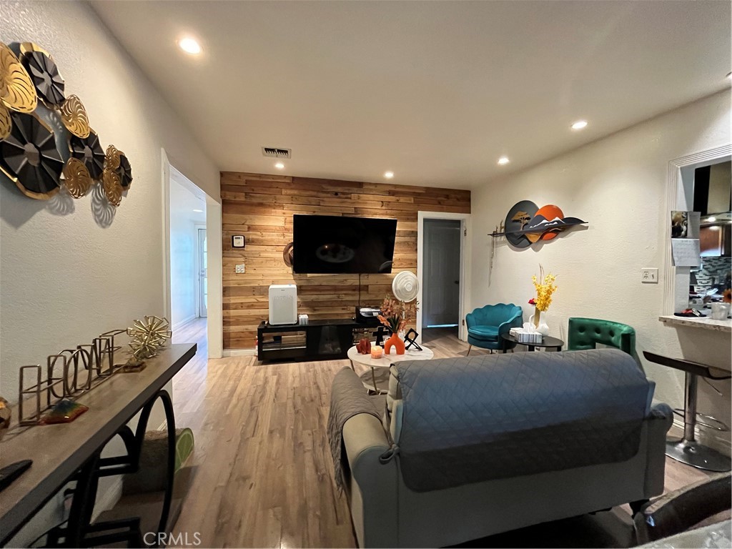 12188 Oracle Street Norwalk, CA 90650 - Photo 7 of 29 a living room with furniture a flat screen tv and a floor to ceiling window