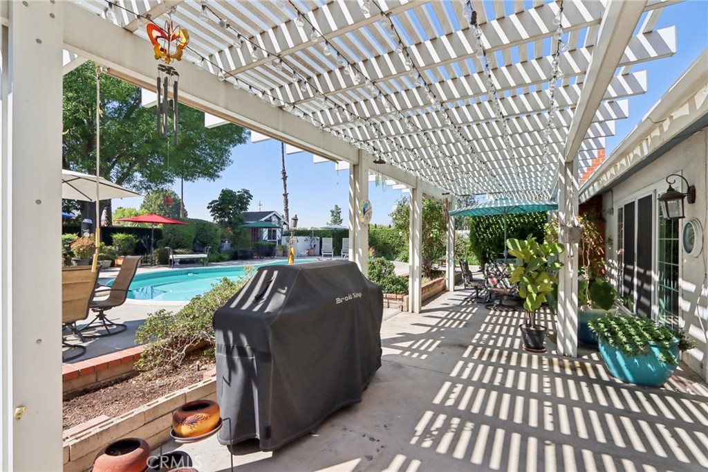 1250 Blazewood Street Riverside, CA 92507 - Photo 19 of 29 a view of a patio with table and chairs barbeque potted plants and large tree