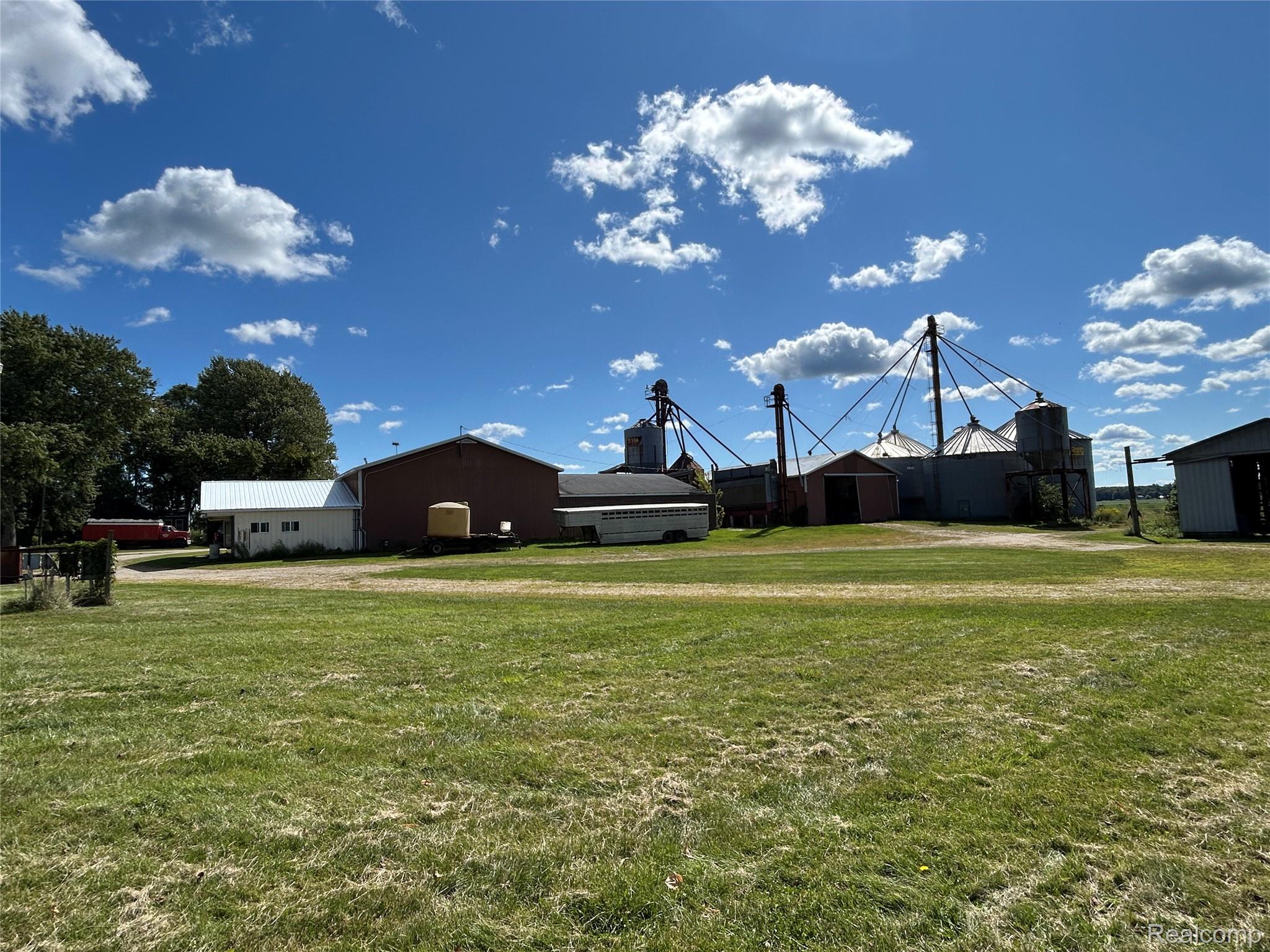 16465 Almont Road Allenton, MI 48002 - Photo 1 of 35 Expansive green space featuring multiple outbuildings, grain silos, and mature trees