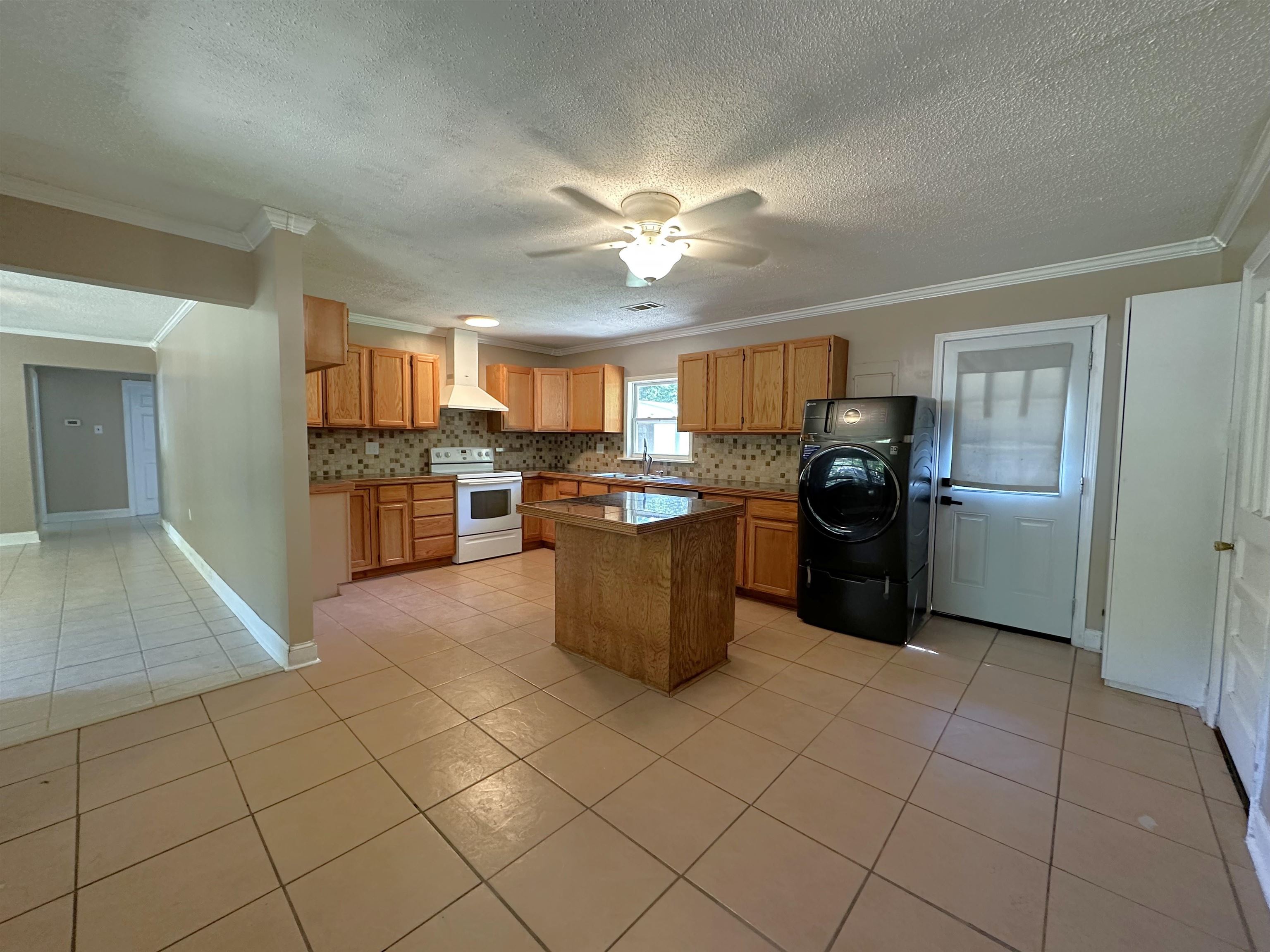 7874 Shamrock Road Millington, TN 38053 - Photo 5 of 17 Spacious kitchen featuring tile flooring, wood cabinetry, stone countertops, a tiled backsplash, and a central island