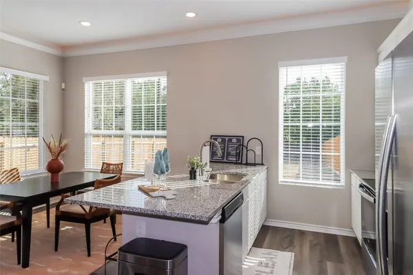 a kitchen with a table chairs and refrigerator