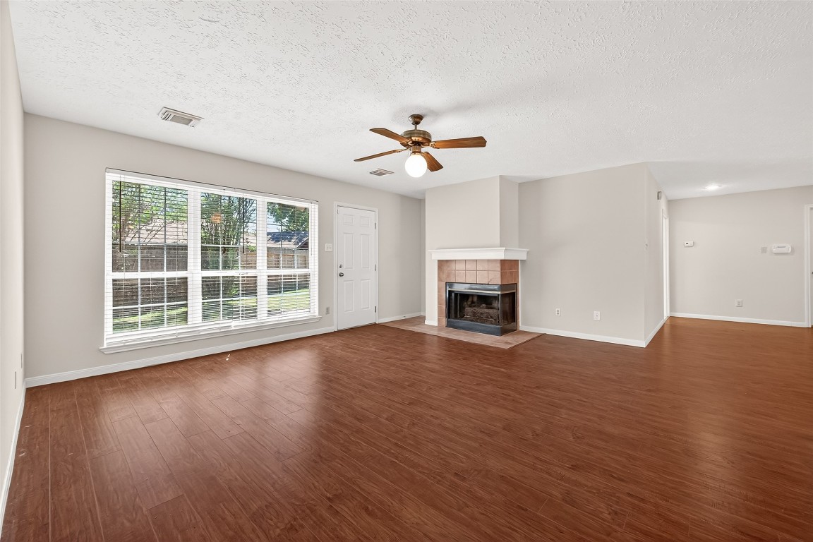 3506 Doherty Place Katy, TX 77449 - Photo 11 of 50 an empty room with windows fireplace and a ceiling fan