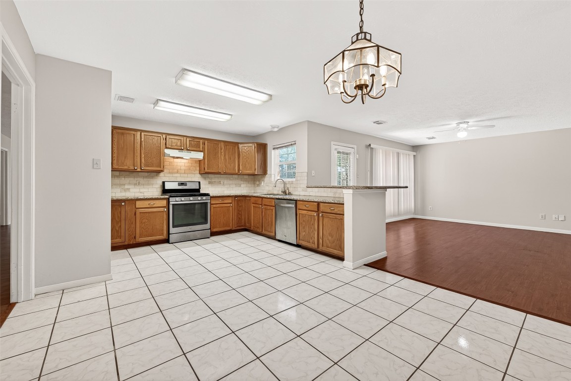 3506 Doherty Place Katy, TX 77449 - Photo 14 of 50 a kitchen with stainless steel appliances granite countertop a stove top oven a sink a counter space and cabinets