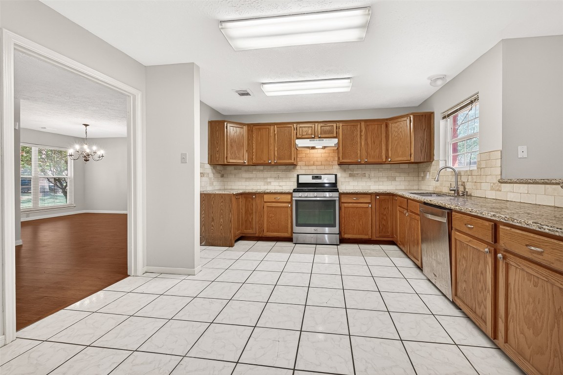 3506 Doherty Place Katy, TX 77449 - Photo 18 of 50 a kitchen with stainless steel appliances granite countertop a refrigerator and a sink