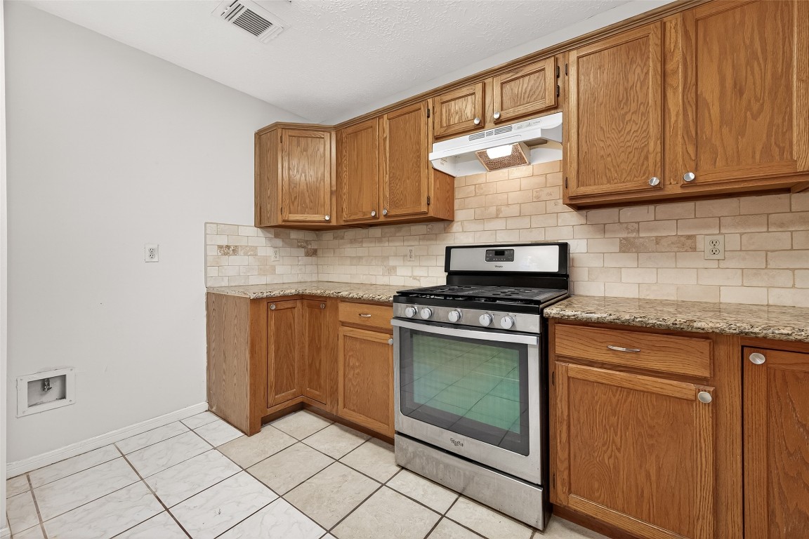 3506 Doherty Place Katy, TX 77449 - Photo 19 of 50 a kitchen with stainless steel appliances granite countertop a stove a sink and a microwave