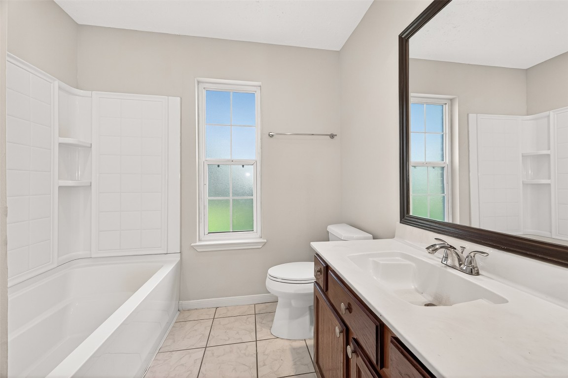 3506 Doherty Place Katy, TX 77449 - Photo 29 of 50 a bathroom with a granite countertop sink a toilet and shower