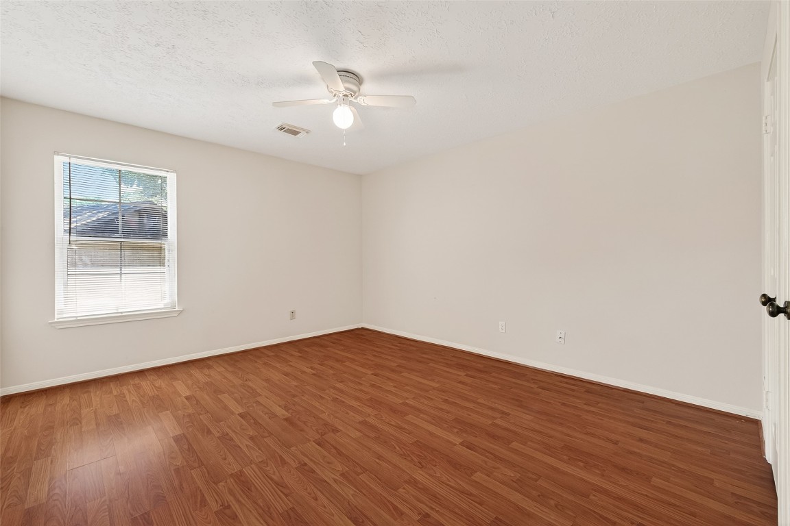 3506 Doherty Place Katy, TX 77449 - Photo 31 of 50 an empty room with wooden floor chandelier fan and windows