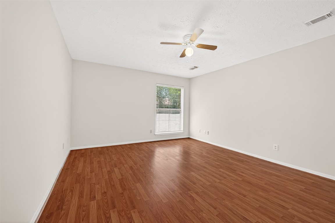 3506 Doherty Place Katy, TX 77449 - Photo 39 of 50 an empty room with wooden floor chandelier fan and windows