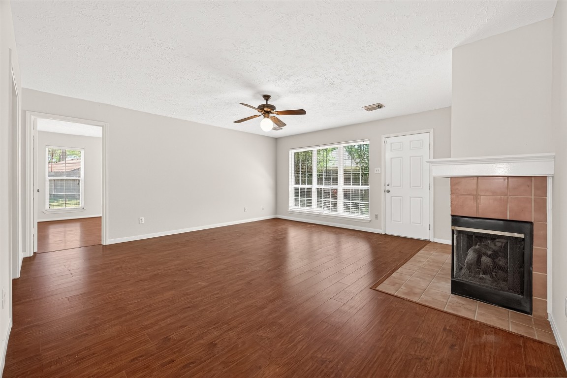 3506 Doherty Place Katy, TX 77449 - Photo 10 of 50 an empty room with wooden floor fireplace and windows