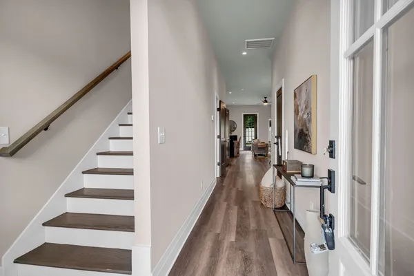 a view of a hallway with a livingroom and furniture