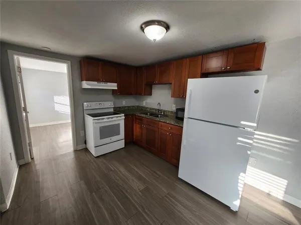 a kitchen with a refrigerator a sink dishwasher and a stove top oven