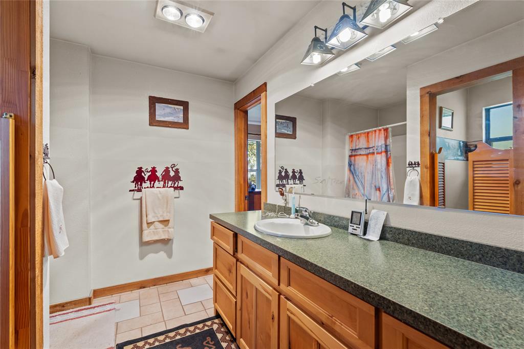 262 North Cheyenne Springtown, TX 76082 - Photo 19 of 35 Full bath with light tile patterned floors, vanity, and a shower with shower curtain