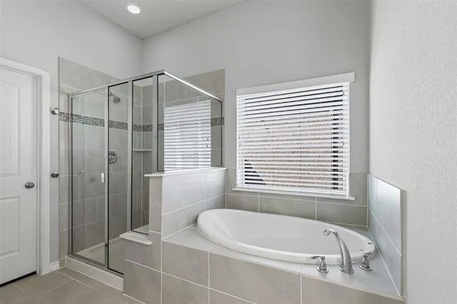 a bathroom with a tub a window and a shower