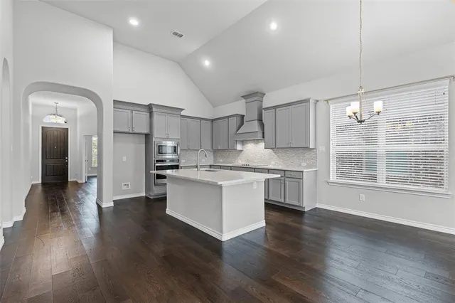 a kitchen with a refrigerator and white cabinets