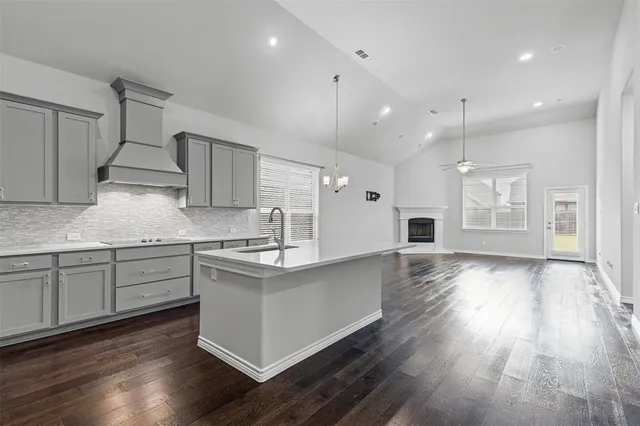 a kitchen with stainless steel appliances granite countertop wooden floors and view living room