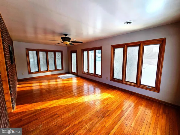 a kitchen with stainless steel appliances kitchen island granite countertop a stove a refrigerator a sink a dining table and chairs with wooden floor
