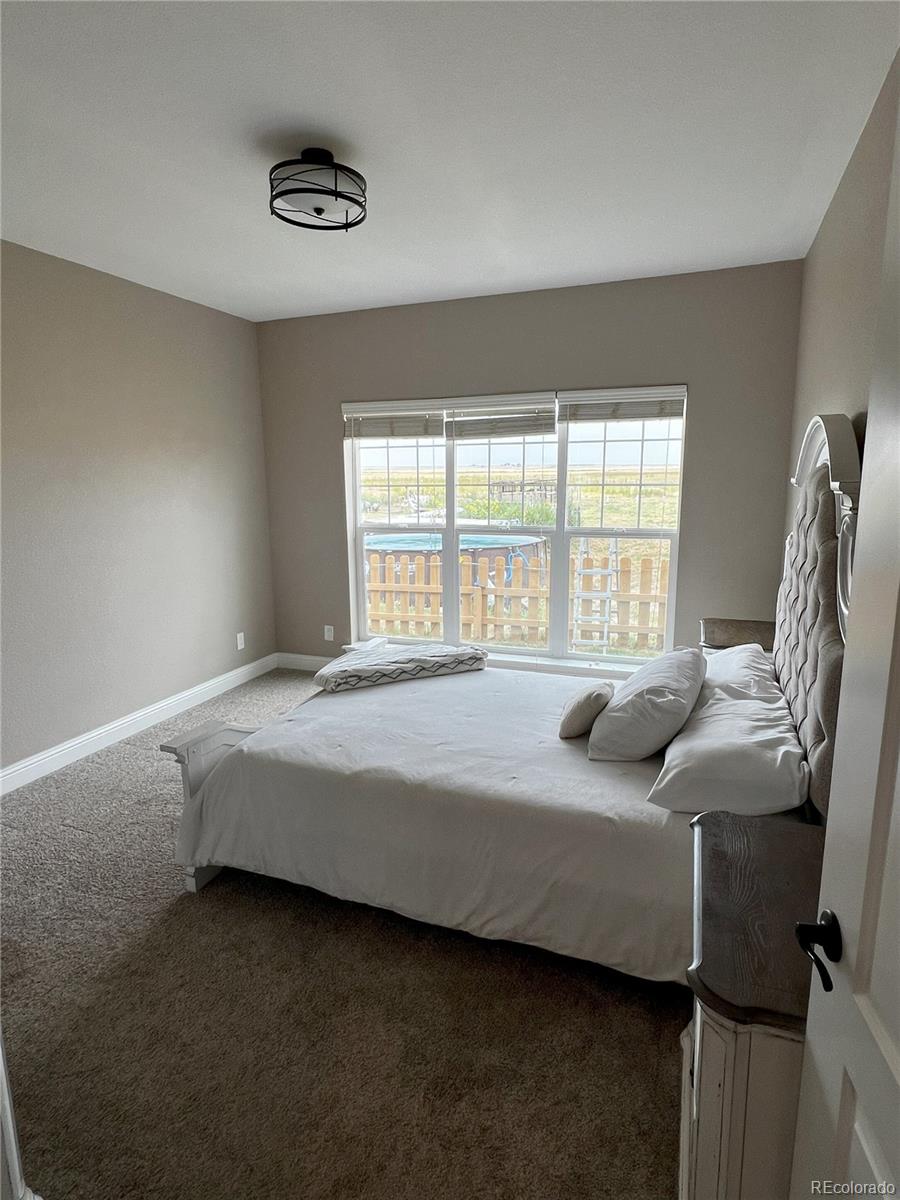 6945 Strasburg Road Strasburg, CO 80136 - Photo 17 of 42 a bedroom with a bed and a window