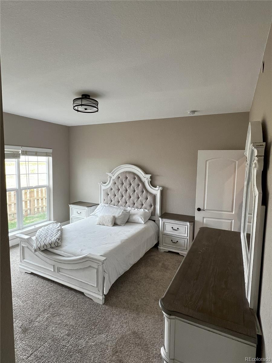 6945 Strasburg Road Strasburg, CO 80136 - Photo 18 of 42 a bedroom with a bed and a couch