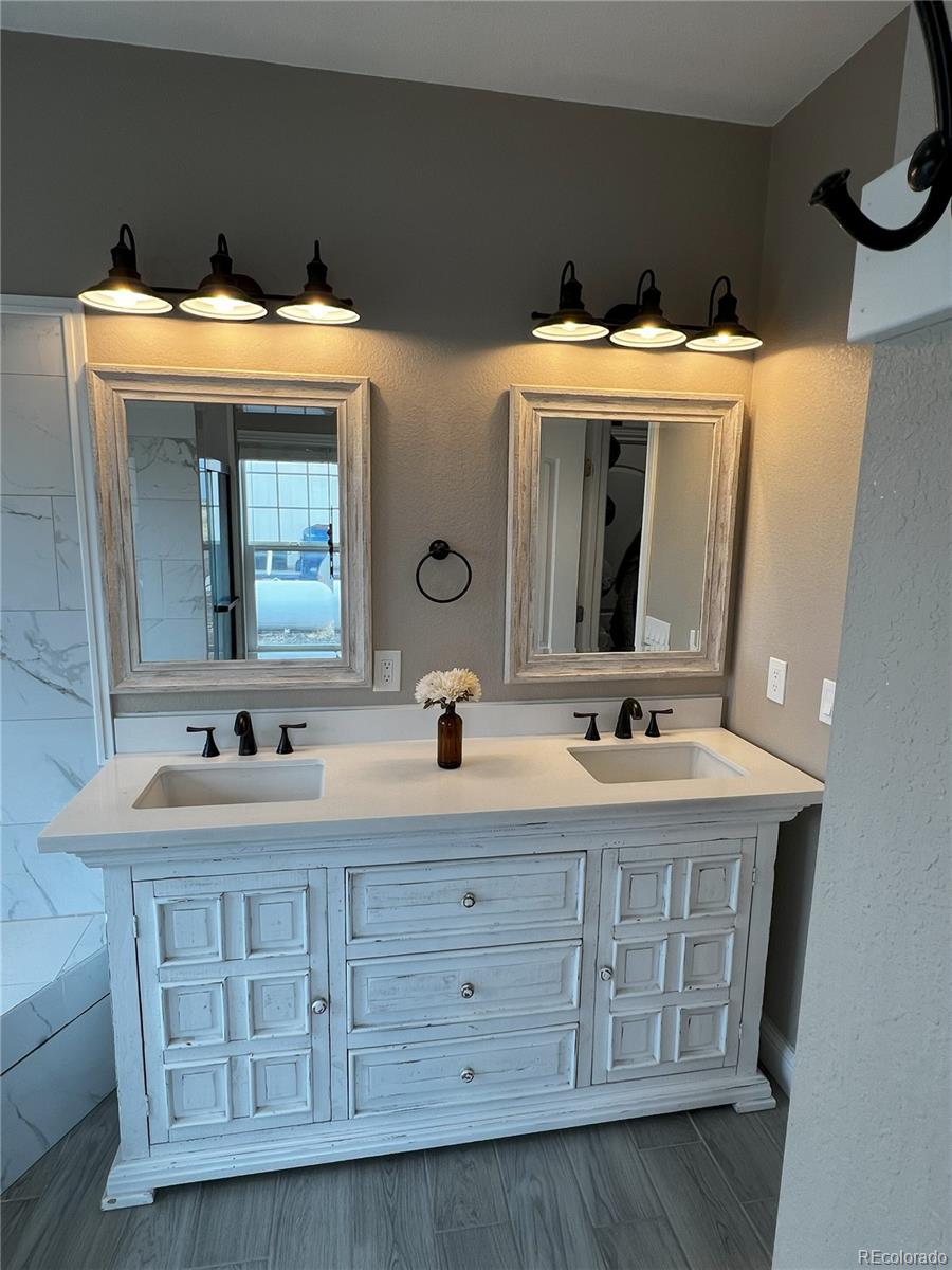 6945 Strasburg Road Strasburg, CO 80136 - Photo 21 of 42 a bathroom with a double vanity sink and a mirror