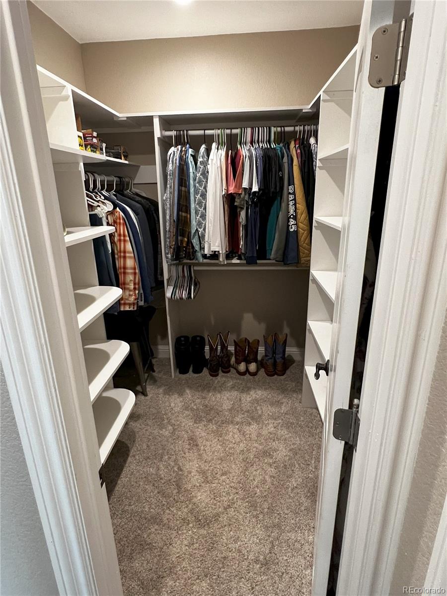 6945 Strasburg Road Strasburg, CO 80136 - Photo 22 of 42 a view of walk in closet with clothes and shoes