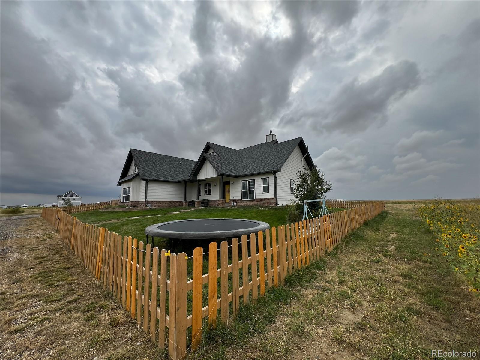 6945 Strasburg Road Strasburg, CO 80136 - Photo 3 of 42 a front view of a house with ocean view