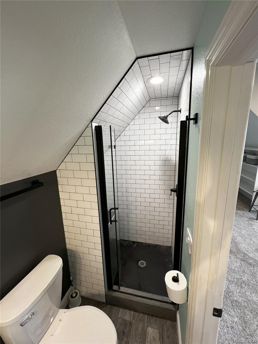 6945 Strasburg Road Strasburg, CO 80136 - Photo 34 of 42 a bathroom with a shower and toilet