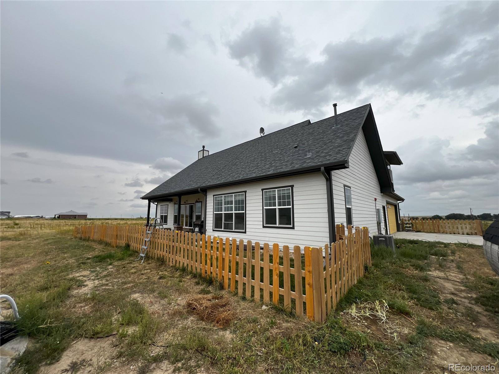 6945 Strasburg Road Strasburg, CO 80136 - Photo 4 of 42 a view of a house with wooden fence