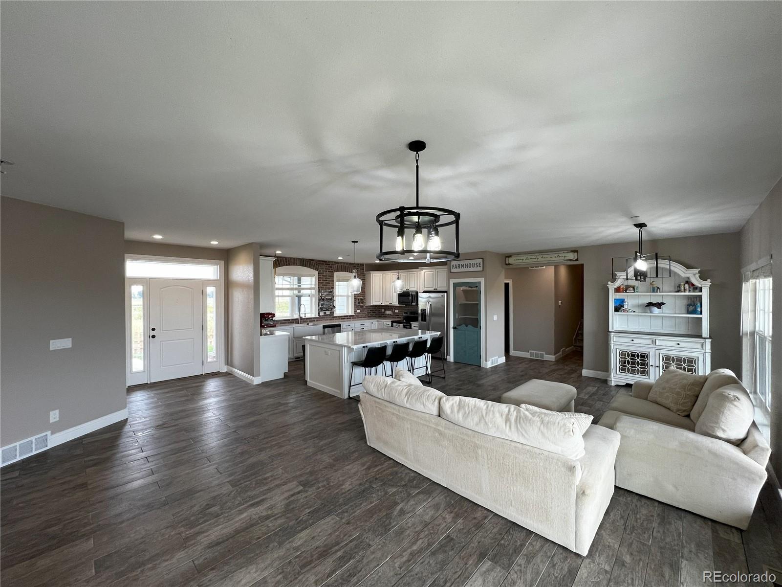 6945 Strasburg Road Strasburg, CO 80136 - Photo 10 of 42 a living room with fireplace furniture and a wooden floor