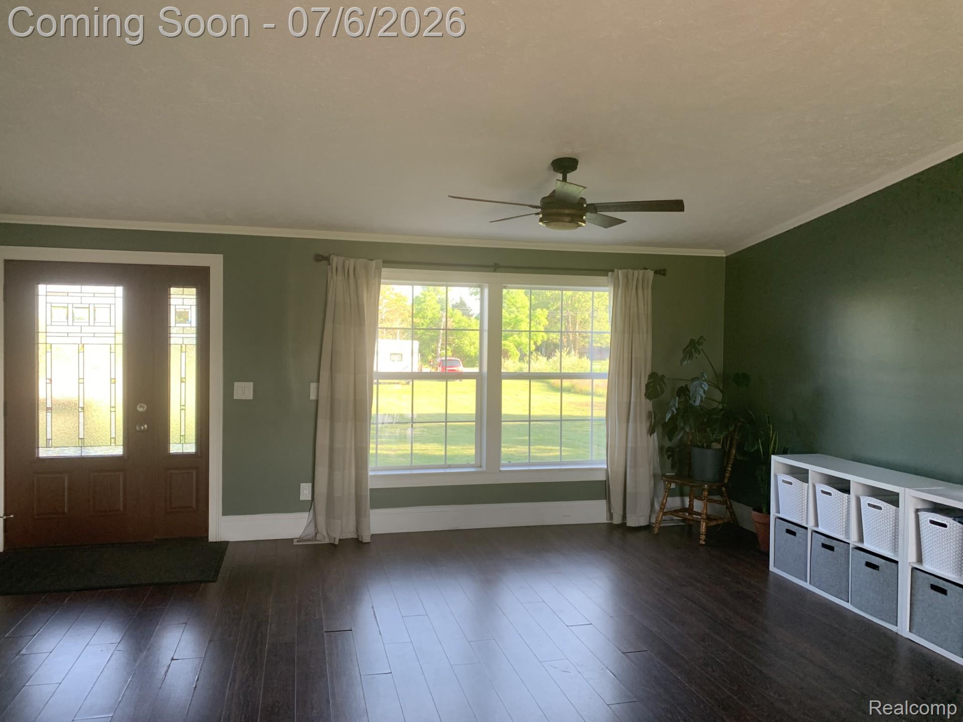 4168 Harris Road Fort Gratiot, MI 48059 - Photo 11 of 30 Entryway and living area featuring dark wood-finish flooring, two large windows, and a ceiling fan
