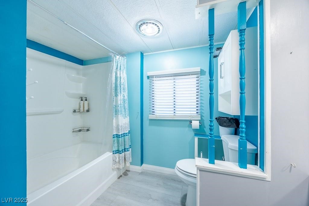 1208 Inca Lane Henderson, NV 89015 - Photo 11 of 21 Full bath featuring a textured ceiling, shower / tub combo with curtain, wood finished floors, and vanity